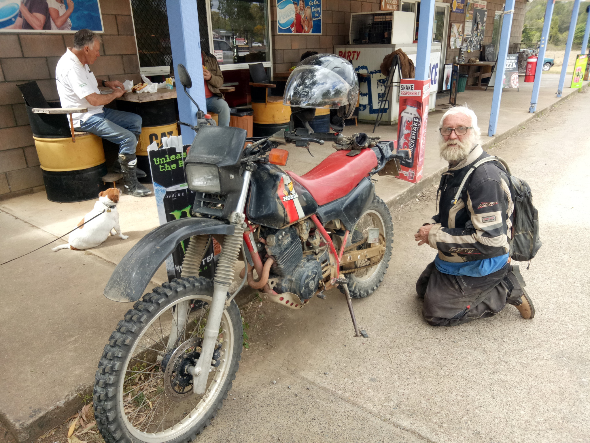 ‘Fish’ sorts out his bike at the servo, during the Pure Earth Rally.