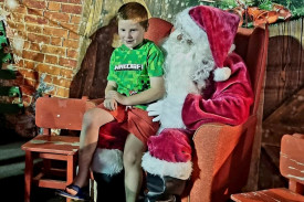 Santa listens to what one of the children would like for Christmas.