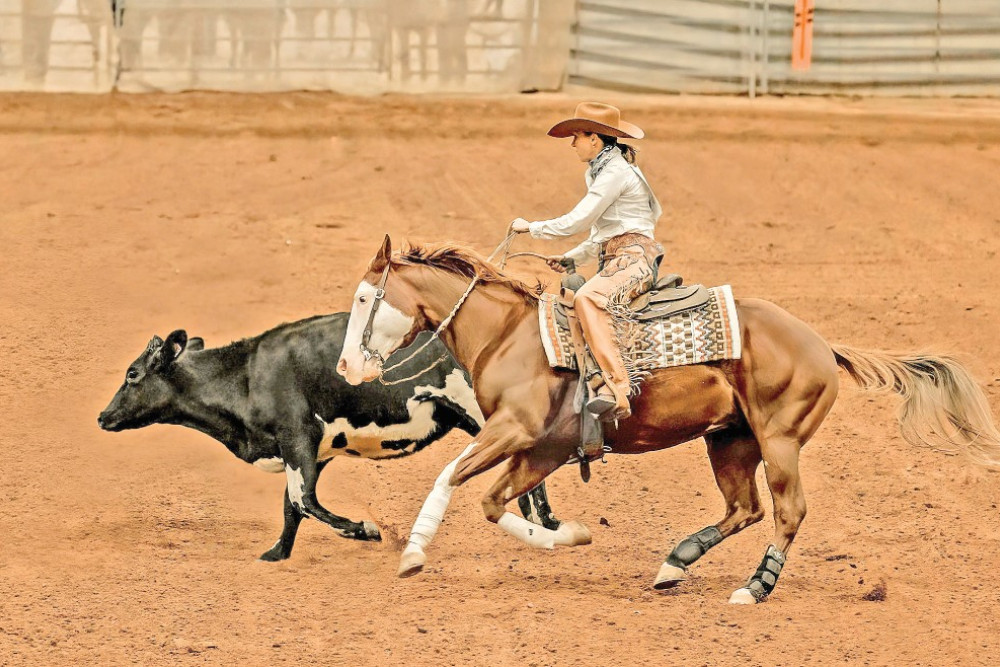 Naomi Lee rides her horse named Red in the reined cow horse event in Australia’s Greatest Horsewoman Competition