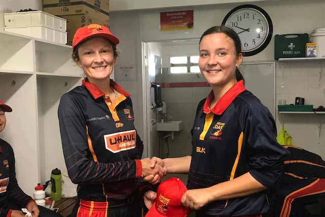 Shari Anderson (right) receives her Sunshine Coast Scorchers first grade cap. The Kilcoy State High School student recently captained a Sunshine Coast team in a 13-15 years state cricket championship.