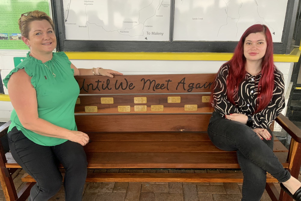 Sam Tetzlaff and Lacey Fry check out the new memorial bench outside the Ray White Rural real estate office in Kilcoy.