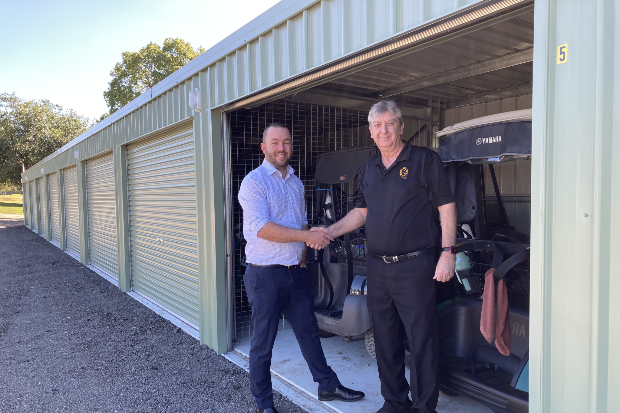 Woodford Golf Club house manager Pat McAtee (right) and Moreton councillor Tony Latter appreciate the addition of a fourth cart shed at Woodford Golf Club.