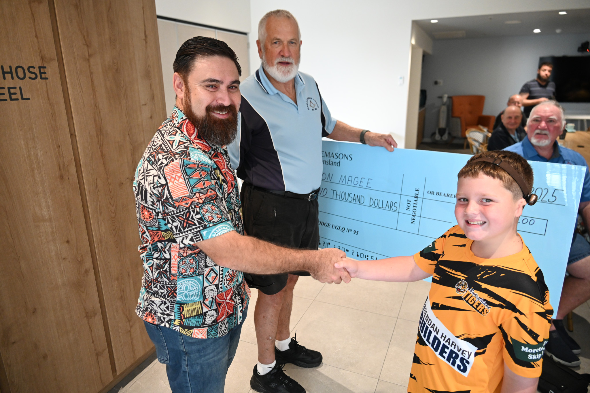 Hudson receives a $2,000 cheque from Morayfield Masonic Lodge.