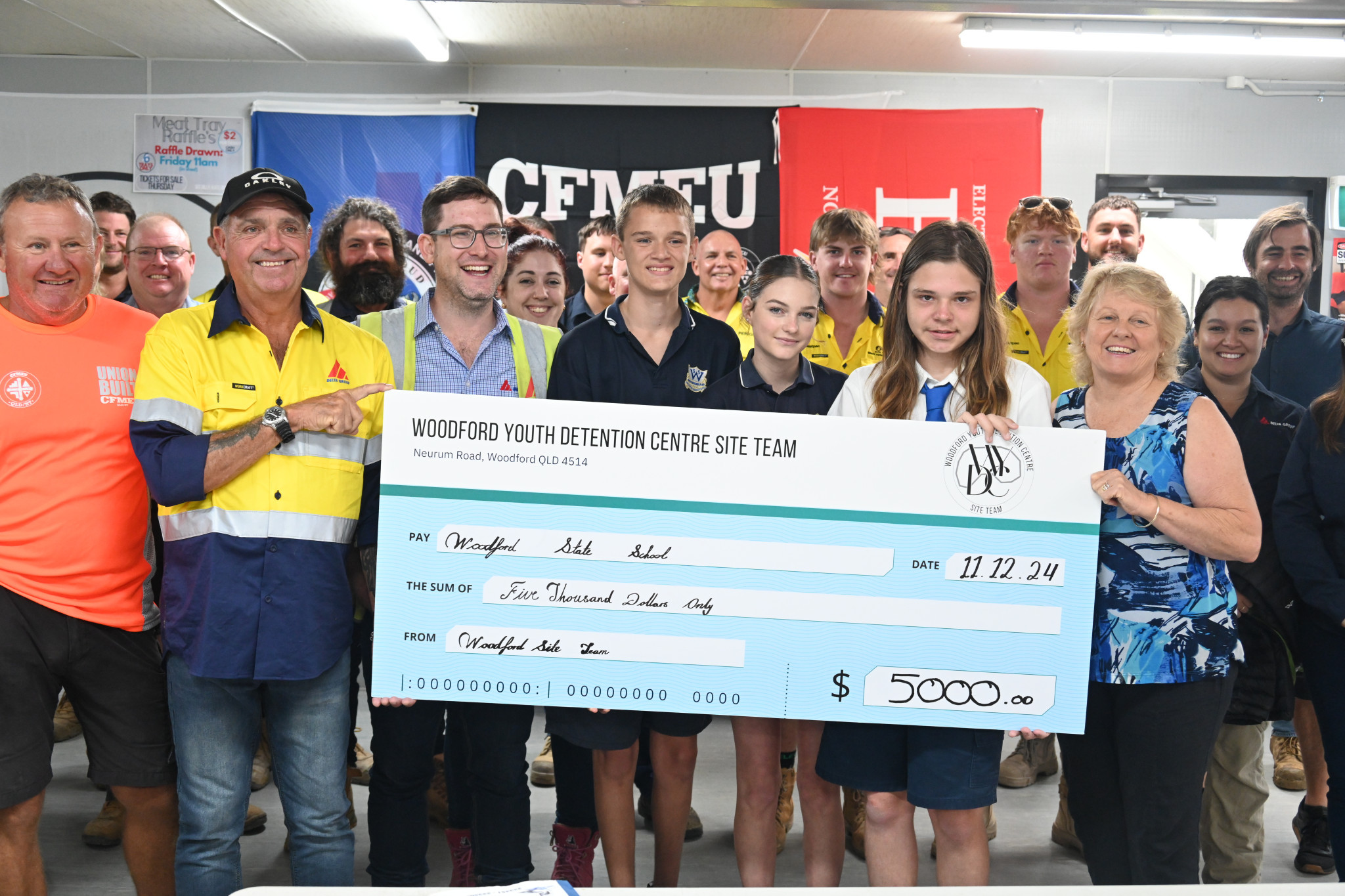 Billy Johnson and Ronan Grealish handing $5,000 to Woodford State School students and principal, Ronnie Hill.