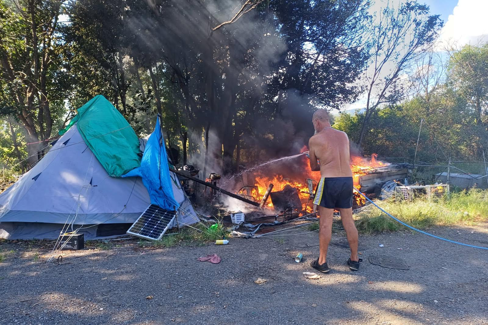 Cruice Park resident putting out deliberate fire set on February 10 at park. Photo: Tyson Purdie.