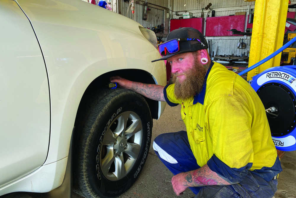 Shane Schofield checks a tyre’s tread depth at Toogoolawah Tyres and Battery